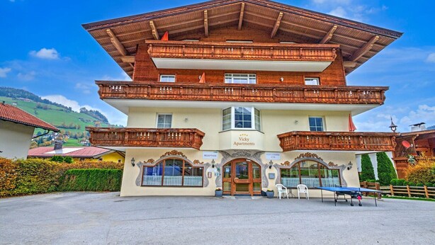 Un edificio di due piani con reception, balconi e un cartello che riporta 'Vicky Apartments'.