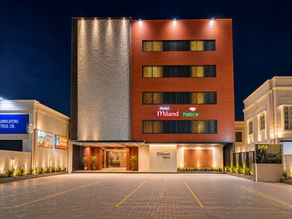 A hotel with a modern facade, a prominent sign for 'Hotel Miland Palace', and a well-lit entrance area. - HOTEL MILAND PALACE (Bhubaneshwar)