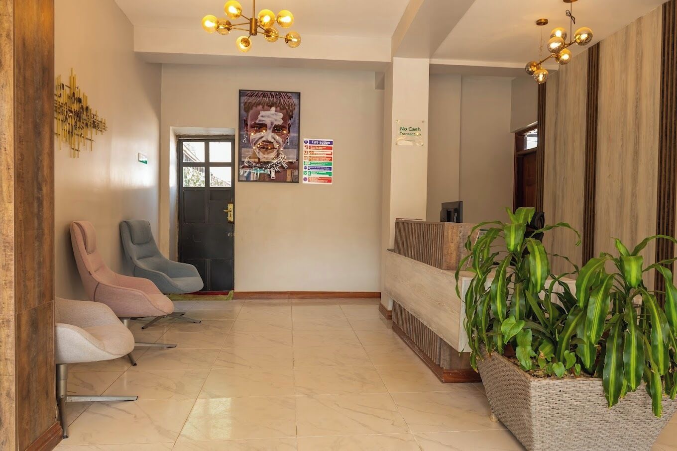 A reception area with a reception desk, a poster, a 'No Cash Transaction' sign, and three chairs.