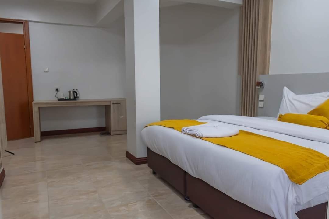 A hotel room with a bed, a desk, and a chair.