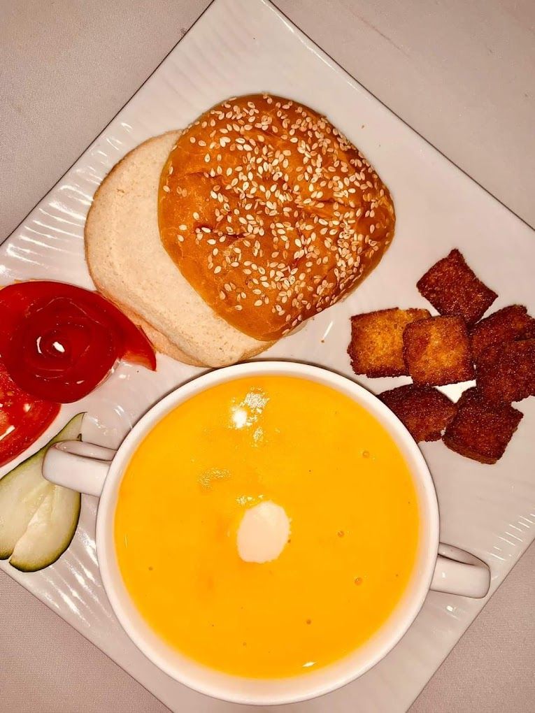 A plate with a sandwich, fries, and a bowl of soup.