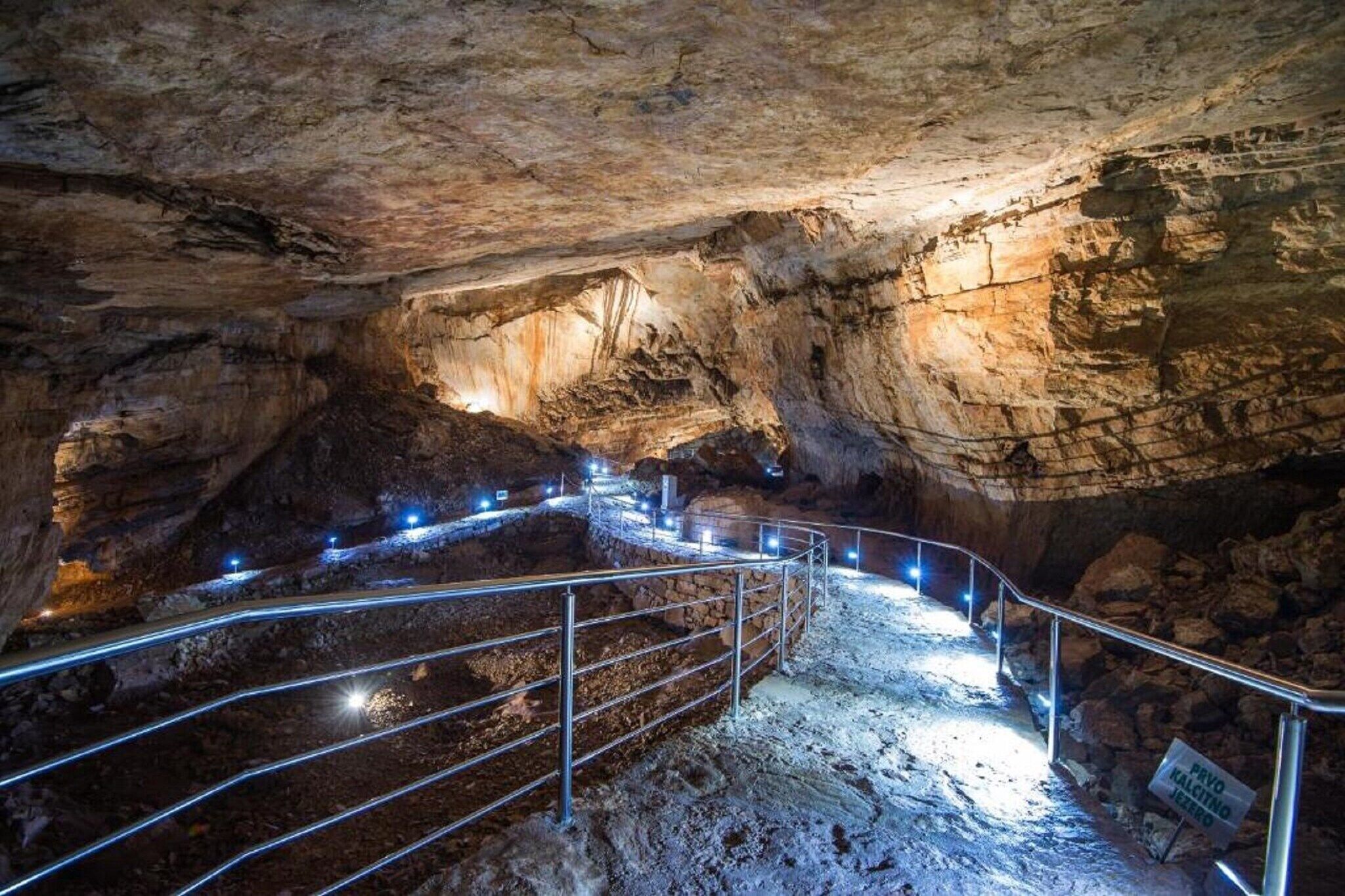 A cave with a metal railing and a sign indicating a restricted area.