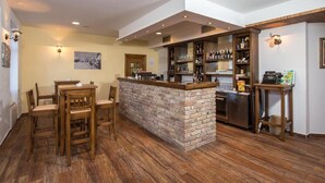 Un espace bar avec un comptoir en briques, des chaises en bois et une table à manger.
