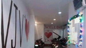 Ein Flur mit einem 'WELCOME'-Schild und einem Herzsymbol, der zu einem Raum mit der Bezeichnung 'Inn' führt.
