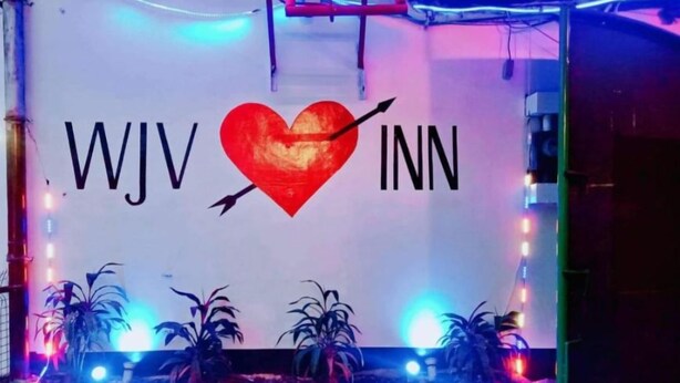 A sign with the text "WJV INN" and a heart symbol, surrounded by decorative lights and potted plants. - WJV INN BASAK  MANDAUE (Mandaue)