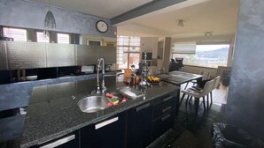 A modern kitchen with a granite countertop, stainless steel appliances, and a view of the outdoors.