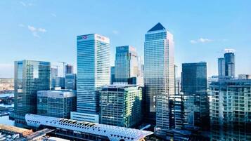 A cityscape with modern high-rise buildings, including recognizable corporate logos.
