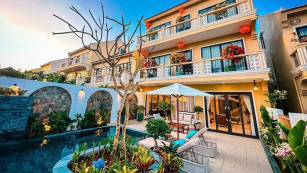 Ein mehrstöckiges Hotel mit Pool, Außenbereich und Balkonen mit Bepflanzung.
