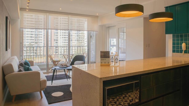 A modern kitchen with a central island, large windows, and a view of the cityscape. - w* | Duplex Cityview 3BR w/ Balcony in Miraflores (Miraflores)