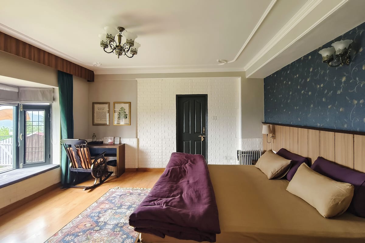 Ein Schlafzimmer mit einem Bett, einem Schreibtisch, einem Stuhl, einem Fenster und einer Tür.