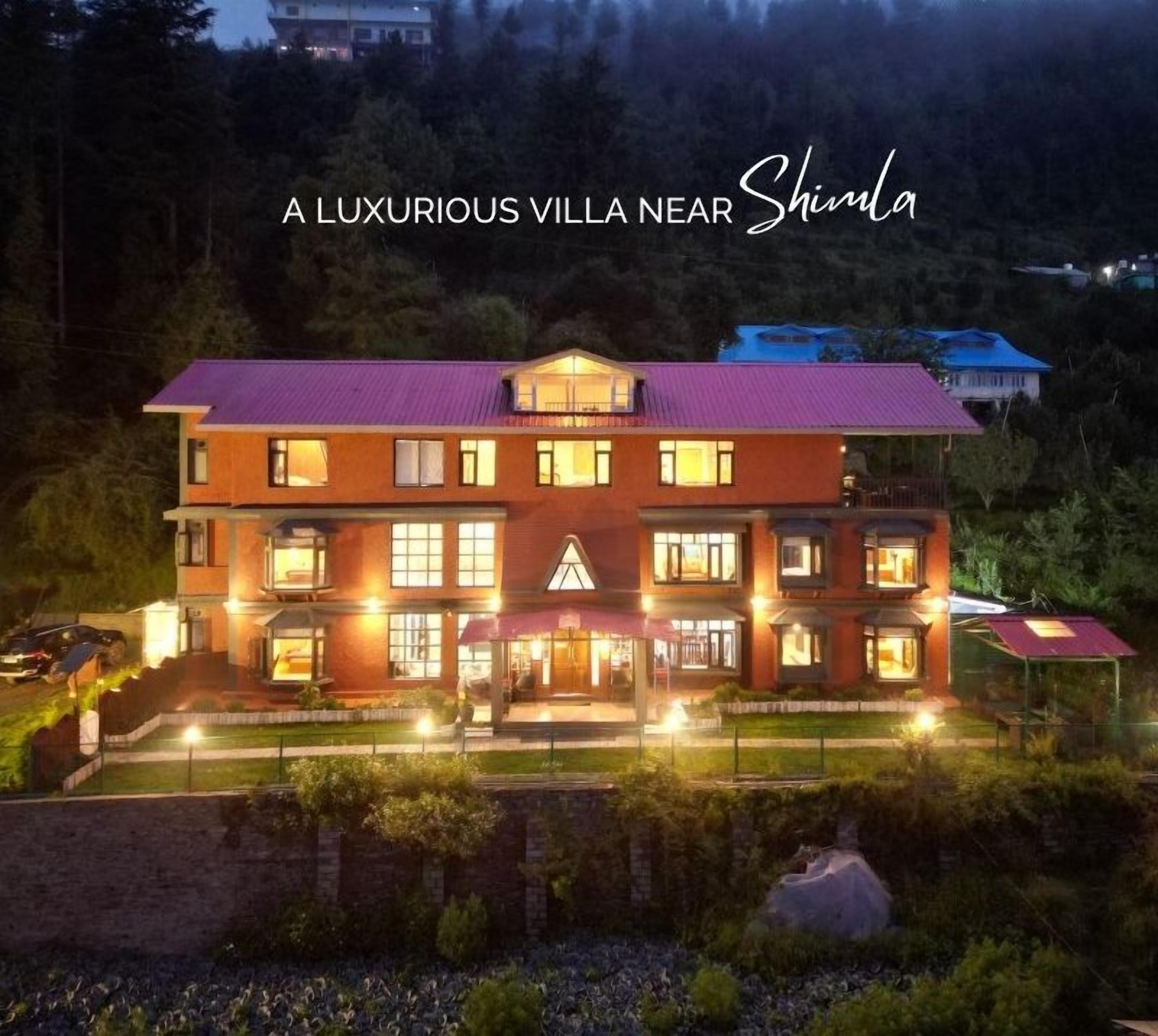 A luxurious villa with multiple floors, large windows, and a well-lit entrance.
