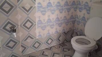 Een douche, handdoeken, zeep, toiletpapier