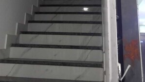 Eine Treppe mit Handlauf auf der rechten Seite, die zu einer Zwischenebene mit einer Tür oben führt.