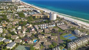 An aerial view of a coastal residential area with beachfront properties, a large hotel, and a tennis court. - Steps from the Sand | Bright Coastal Stay w/ Pool Access | Coastal Hideaway (Destin)