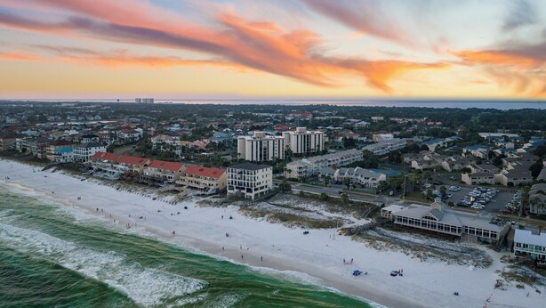 An aerial view of a coastal town with a beach, buildings, and a clear sky. - Steps from the Sand | Bright Coastal Stay w/ Pool Access | Coastal Hideaway (Destin)