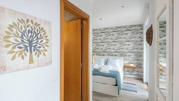 Una camera da letto moderna con un letto, una porta in legno e una parete con motivo decorativo.