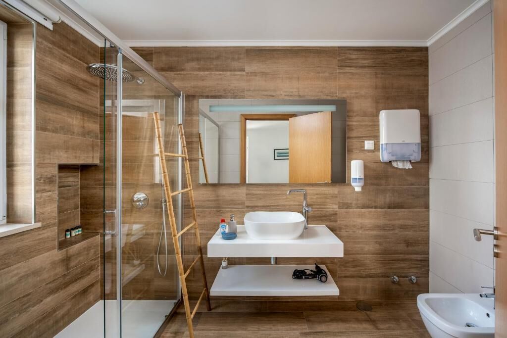 A modern bathroom with a glass shower enclosure, a white sink, and a vanity.