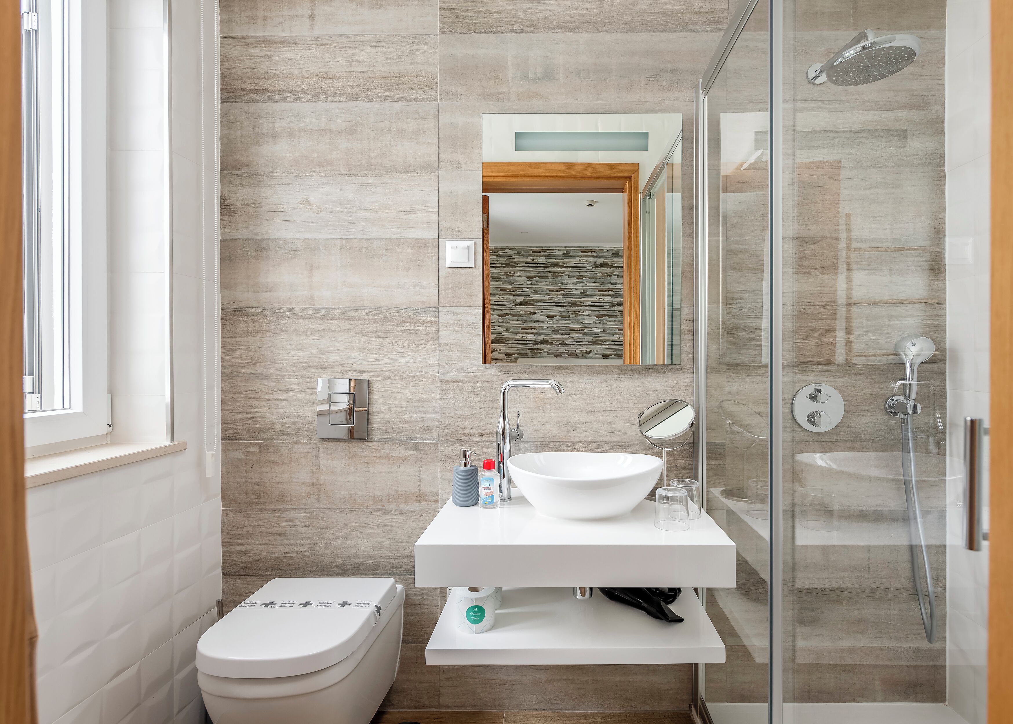 A modern bathroom with a toilet, sink, and shower.