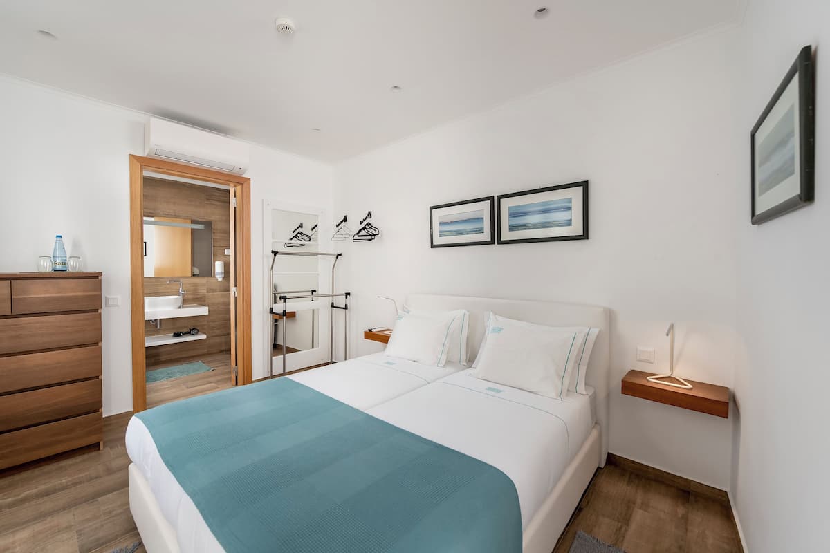 Ropa de cama hipoalergénica y caja de seguridad en la habitación 