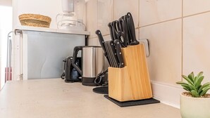 Un plan de travail de cuisine avec un range-couteaux, une machine à café et une bouilloire.
