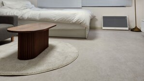 Een moderne hotelkamer met een bed, nachtkastje en bureau met lamp.
