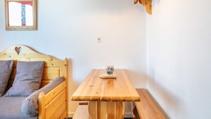 A cozy room with a wooden bed, a wooden bench, and a small table. - Mountain Hideaway in Risoul (Risoul)