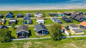 Een woongebied aan de kust met huizen, een strand en een heldere lucht.