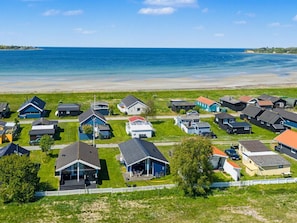 Une zone résidentielle côtière avec des maisons, une plage et un ciel dégagé.