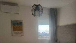 Hotelkamer met een bed, raam met uitzicht, schilderij aan de muur en een hanglamp.