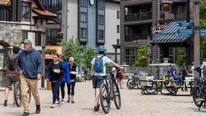 Une rue piétonne bordée de bâtiments, où l’on peut voir des vélos et des terrasses.