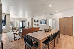Un intérieur moderne comprenant un coin repas, des sièges et une cuisine visible au fond.