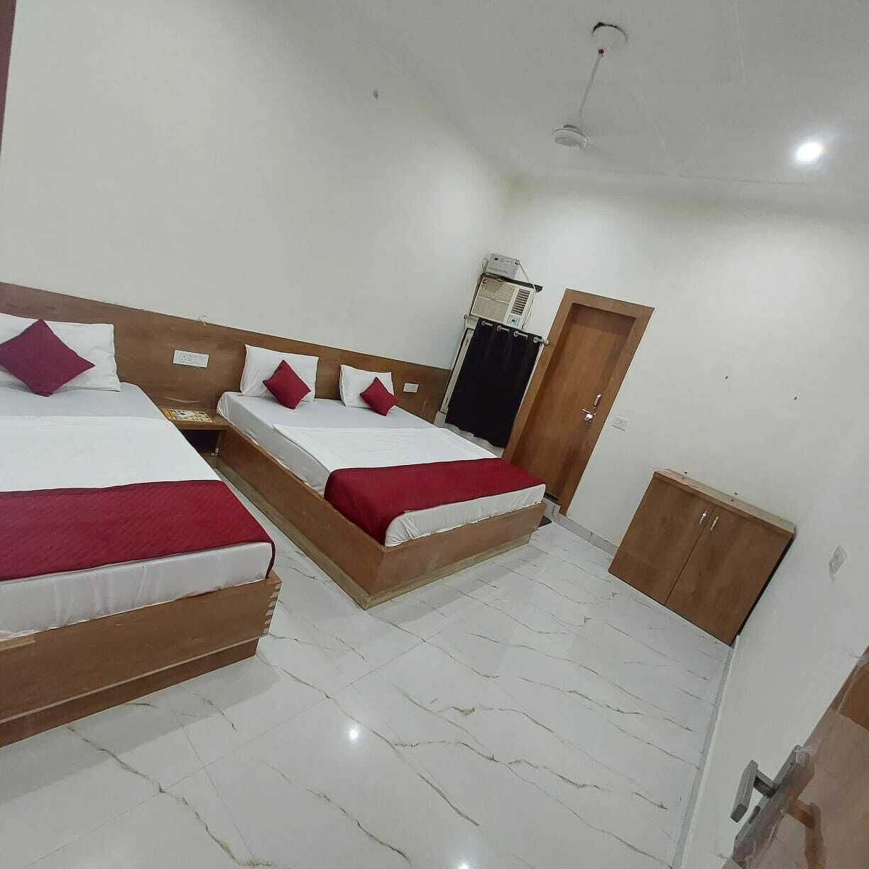 Una habitación de hotel con dos camas, un armario y un ventilador de techo.
