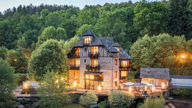A stone building with multiple balconies, a stone bridge, and a small stream. - Le Moulin de Cambelong (Conques-en-Rouergue)