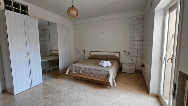 A bedroom with a bed, a wardrobe, a mirror, and a window. - CconfortHotels Dimora Cavour (Bari)