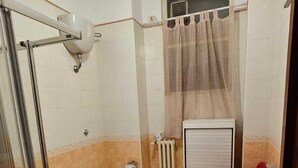 A bathroom with a glass shower enclosure, two toilets, a bidet, a radiator, and a sink. - CconfortHotels Dimora Cavour (Bari)