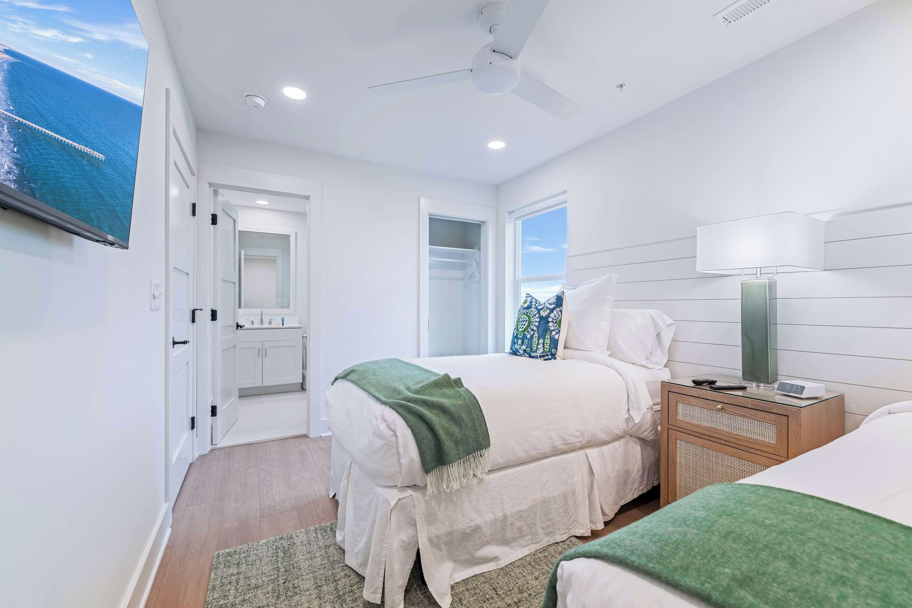 Un dormitorio moderno con cama, mesita de noche y ventilador de techo.