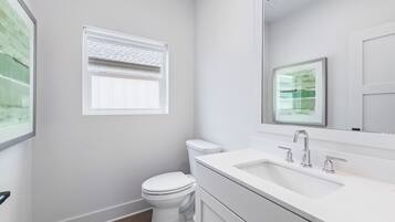 Un baño moderno con inodoro, lavamanos y ventana.