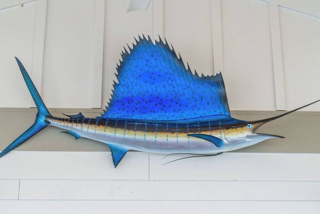 A large, detailed sculpture of a fish, possibly a sailfish, mounted on a wall.