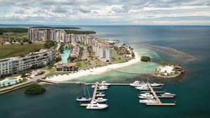 A coastal resort with multiple high-rise buildings, a marina with yachts, and a beach area.