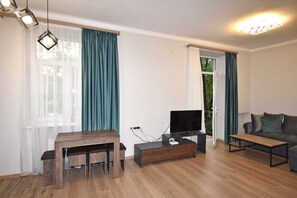 Appartamento Basic, balcone, vista parco | Area soggiorno | TV a schermo piatto 50 pollici con canali via cavo