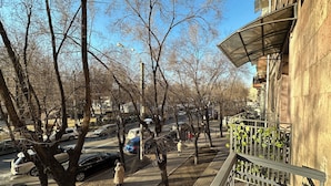 Una calle arbolada con coches aparcados y una acera para peatones.