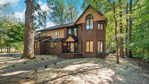 A two-story house with a brick exterior, large windows, and a covered porch. - Deer Run Lodge/Indoor Pool/Basketball/Hot Tub (Terre Haute)