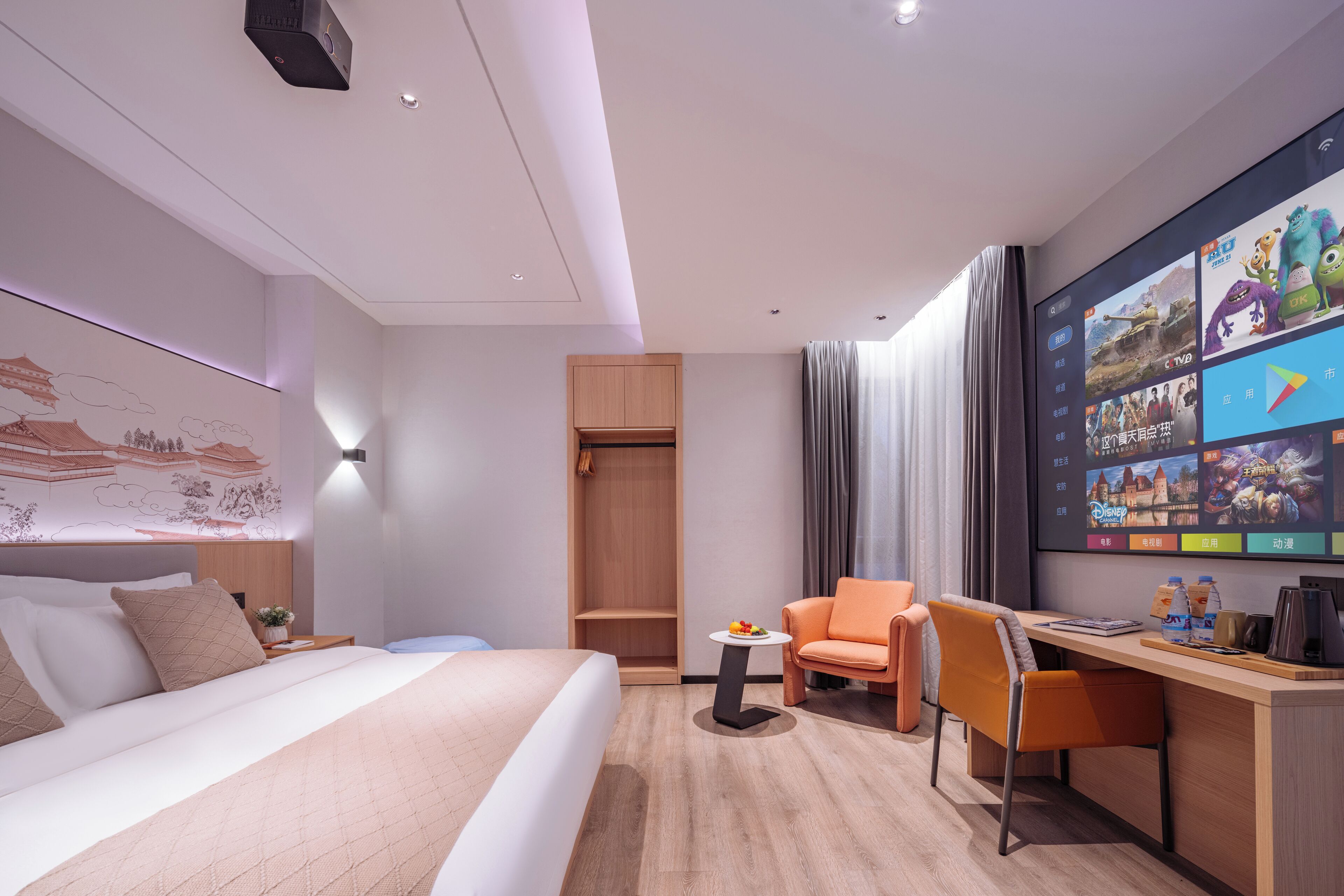 Une chambre d’hôtel moderne équipée d’un grand lit, d’un bureau avec une chaise, d’une petite table avec une plante et d’un téléviseur diffusant diverses chaînes.