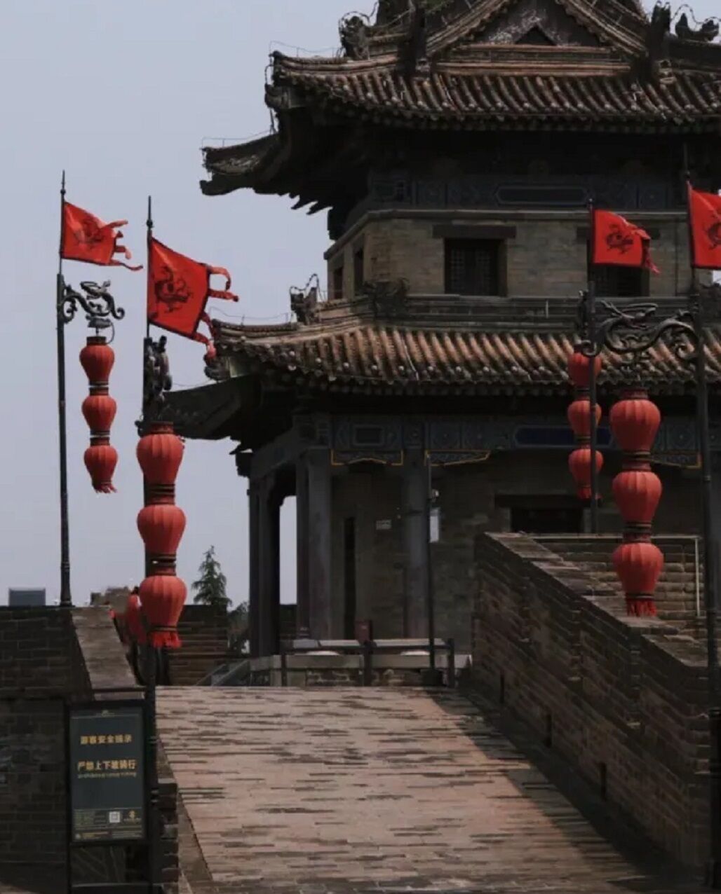 A traditional building with a tiled roof and red lanterns.
