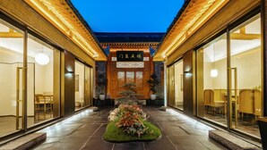 Un bâtiment traditionnel doté d’une cour intérieure, de poutres en bois et d’une enseigne ornée de caractères chinois.