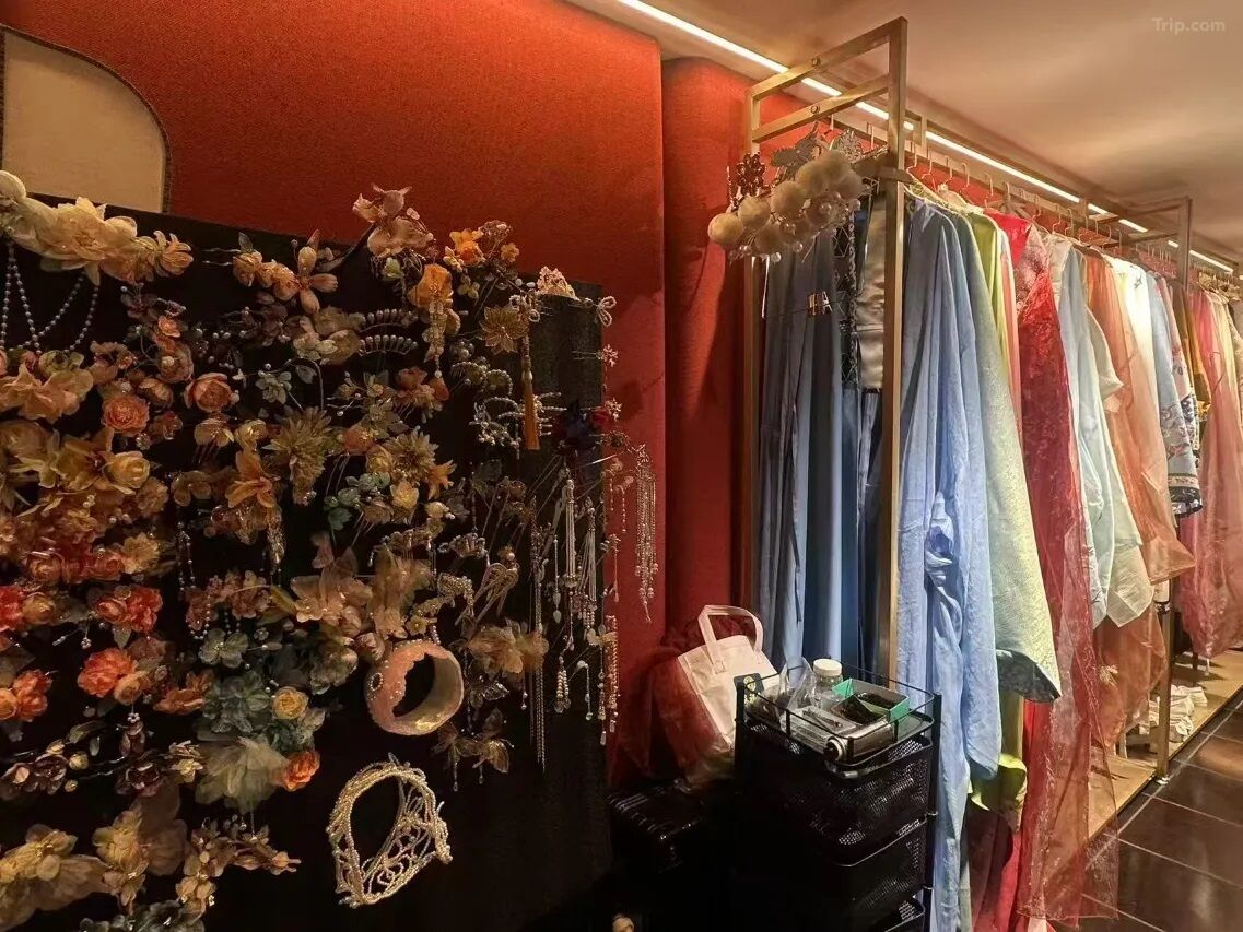 Una tienda de ropa con perchas llenas de vestidos y una pared decorada con diversos objetos.