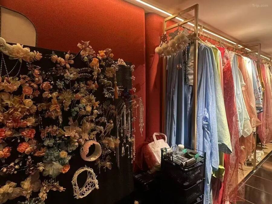Una tienda de ropa con perchas llenas de vestidos y una pared decorada con diversos objetos.
