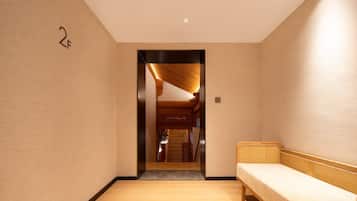 A hallway with a wooden bench, a door labeled "2F", and a staircase leading to another room.