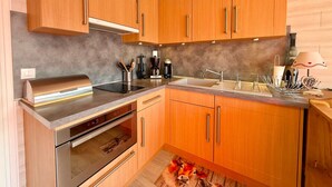A modern kitchen with wooden cabinets, stainless steel appliances, and a built-in oven.