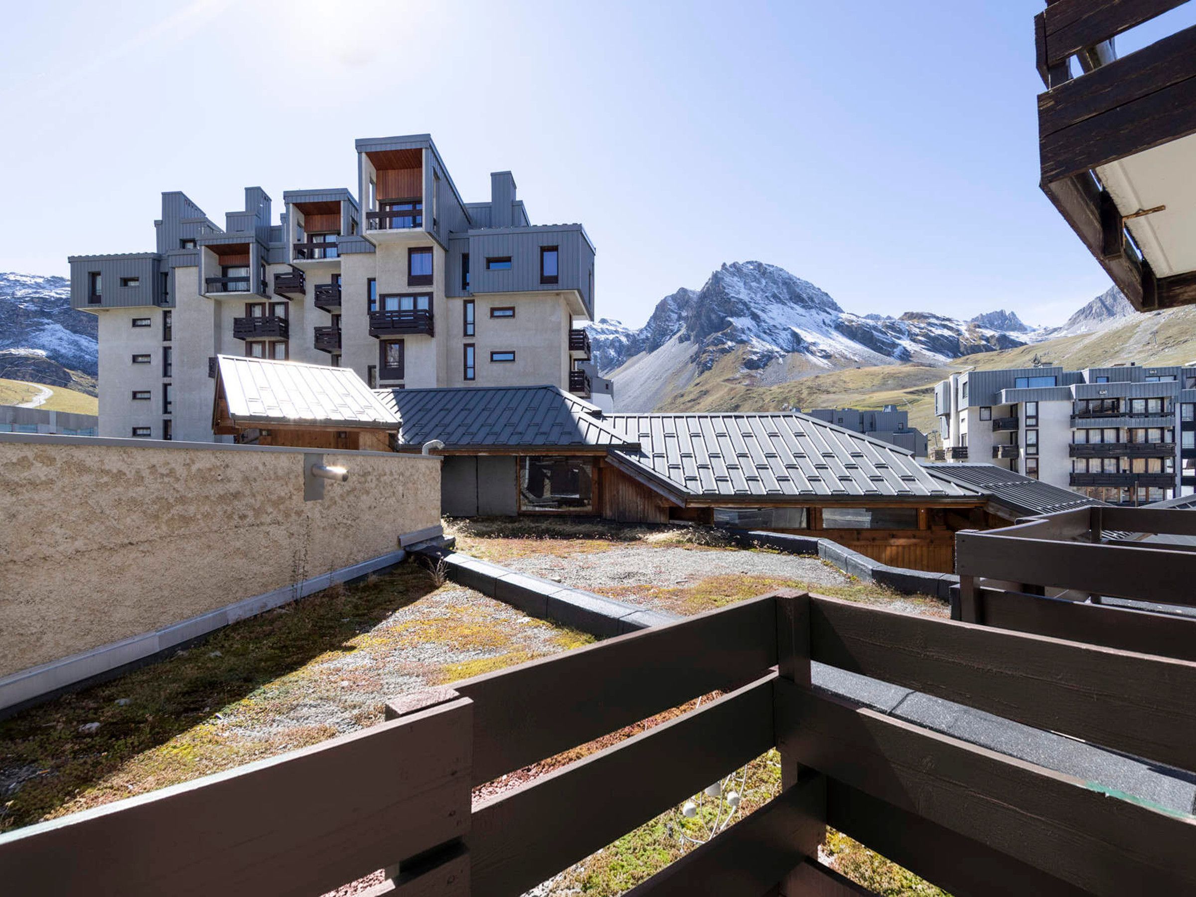 Ein modernes Gebäude mit mehreren Balkonen und einem Bergpanorama.